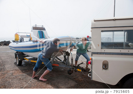 Two young men fixing dinghy trailer to vehicle Two young men fixing dinghy trailer to vehicle 7915605