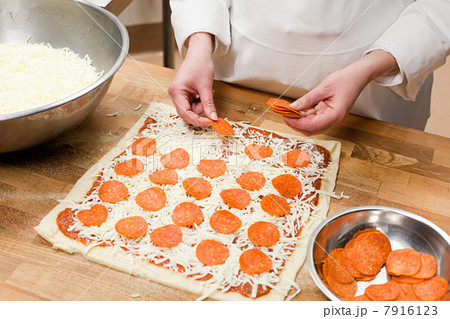 Female chef making pizza in commercial kitchen 7916123