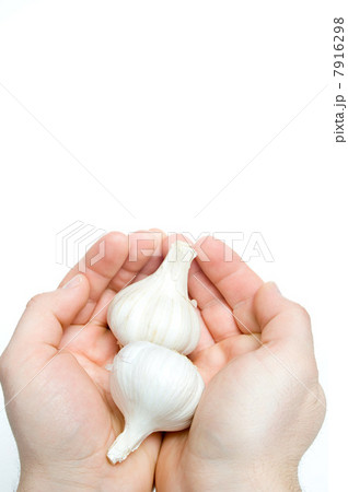Person holding garlic bulbs 7916298