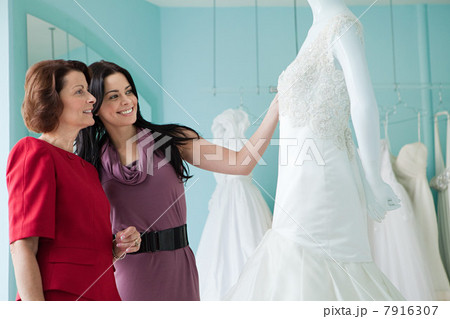 Mother and daughter looking at wedding dresses 7916307