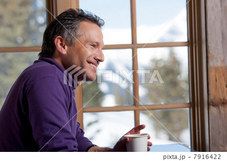 Mature man holding hot drink indoors, smiling Mature man holding hot drink indoors, smiling 7916422