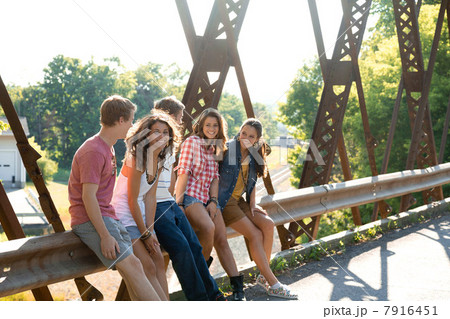 Group of friends sitting on bridge 7916451