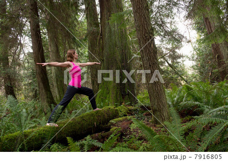 Mature woman performing warrior pose in forest Mature woman performing warrior pose in forest 7916805