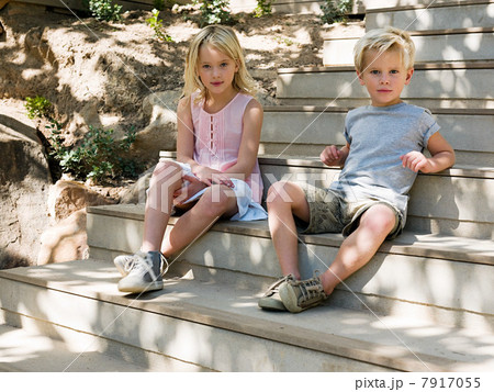 Brother and sister sitting on wooden steps, portrait 7917055