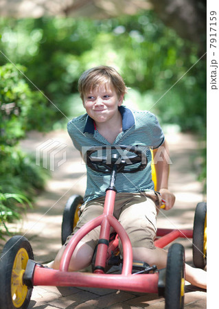 Boy riding go-kart on path 7917159