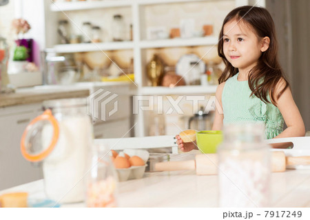 Young girl at kitchen counter measuring ingredients 7917249