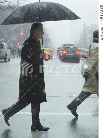 Mature man crossing city street in rain 7917280