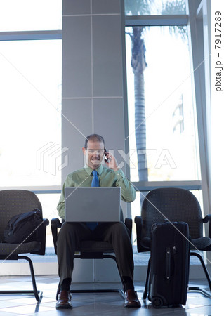 Businessman on cell phone using laptop 7917289