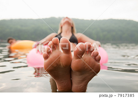 Close up of young woman floating in lake 7917385