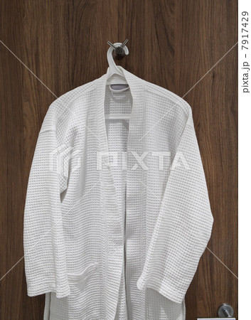White bathrobe hanging on door 7917429