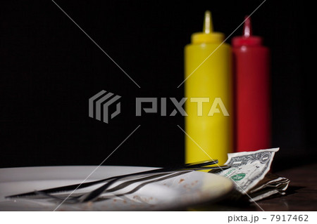 Money on table next to mustard and tomato sauce Money on table next to mustard and tomato sauce 7917462