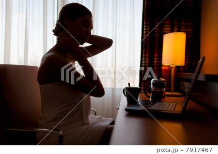 Young woman sitting at laptop in hotel room Young woman sitting at laptop in hotel room 7917467