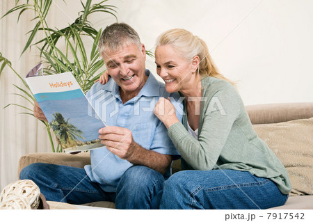 Mature couple with holiday brochure 7917542