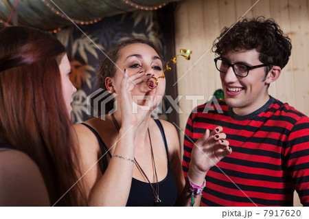 Young blowing streamer with friends 7917620
