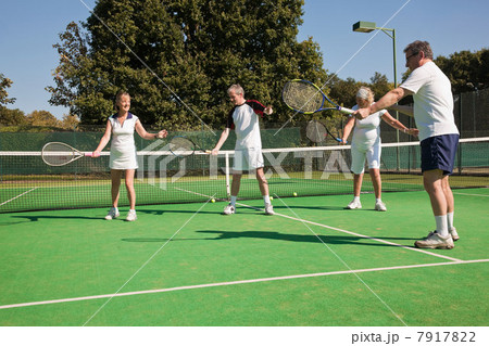 Senior and mature adults practising on tennis courts 7917822