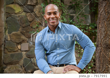 Smiling man sitting outdoors 7917991