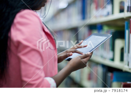 Female student using digital tablet in library 7918174