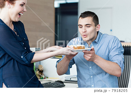 Man blowing out candles on birthday cake 7918205