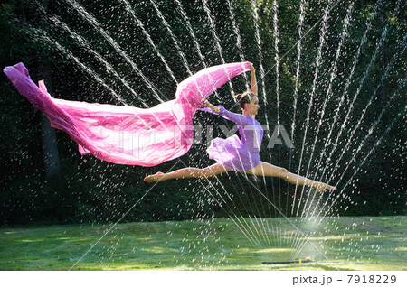 Ballerina leaping over water sprinkler with fabric 7918229