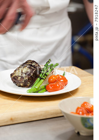 Male chef preparing meal in commercial kitchen 7918247