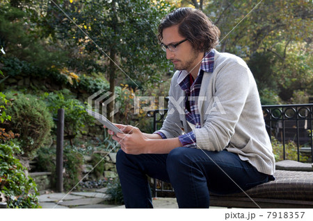 Man using tablet computer outdoors 7918357