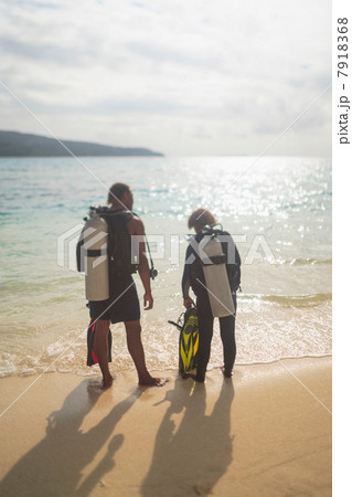Scuba divers walking on tropical beach 7918368