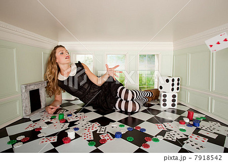 Young woman in small room throwing playing card 7918542