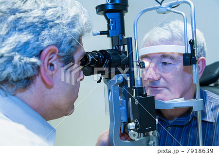 Doctor giving patient eye exam 7918639