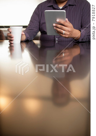 Mid adult man using digital tablet 7918827