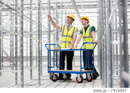 Two men in empty warehouse with trolley Two men in empty warehouse with trolley 7918847