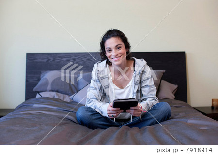Young woman sitting bed with electronic book, portrait Young woman sitting bed with electronic book, portrait 7918914
