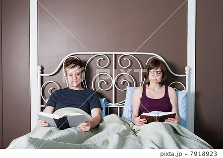 Young couple reading in bed Young couple reading in bed 7918923
