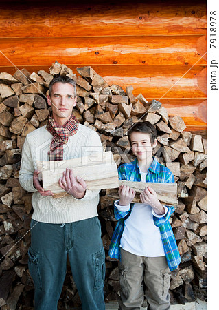 Father and son holding logs, portrait 7918978