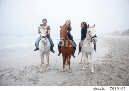 People riding horse on beach 7919165