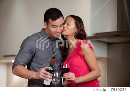 Couple having wine together in kitchen Couple having wine together in kitchen 7919225