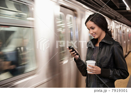 Woman using cell phone at subway station 7919301