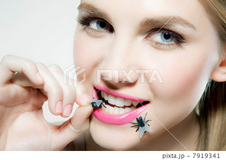 Young woman biting plastic fly Young woman biting plastic fly 7919341