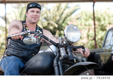 Man in leather vest on motorcycle 7919456