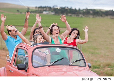Friends cheering in convertible 7919679