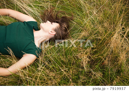 Young woman lying down in a field 7919937