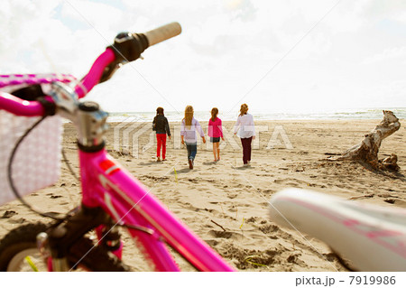 Girls walking over sand at beach 7919986