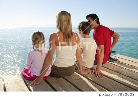 Family sitting on jetty together 7920008