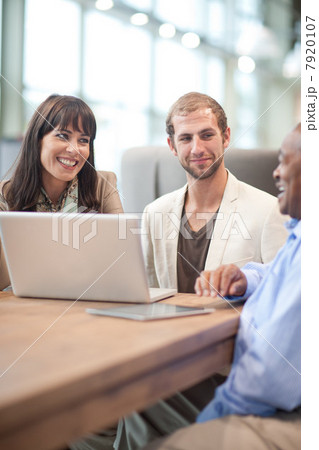 Businessman using laptop with colleagues Businessman using laptop with colleagues 7920107