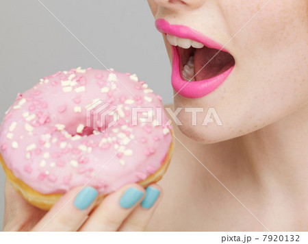 Woman wearing pink lipstick eating doughnut 7920132