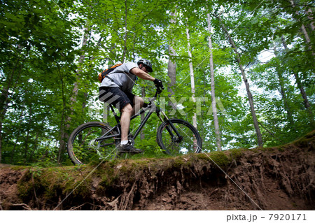 Man mountain biking on ledge 7920171