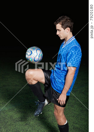 Young man with soccer ball on pitch 7920180