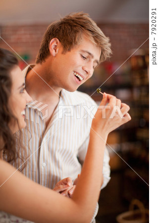Couple tasting olives in grocery 7920291