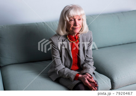 Senior woman sitting on sofa with blank expression Senior woman sitting on sofa with blank expression 7920467