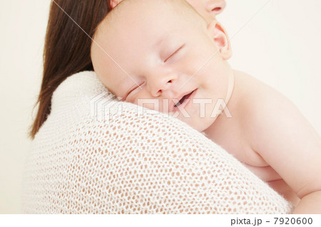 Mother with newborn baby sleeping on shoulder 7920600
