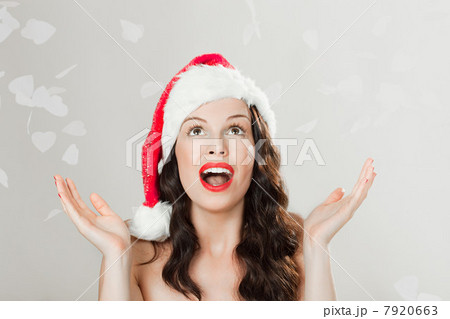 Young brunette woman wearing Santa hat with confetti Young brunette woman wearing Santa hat with confetti 7920663